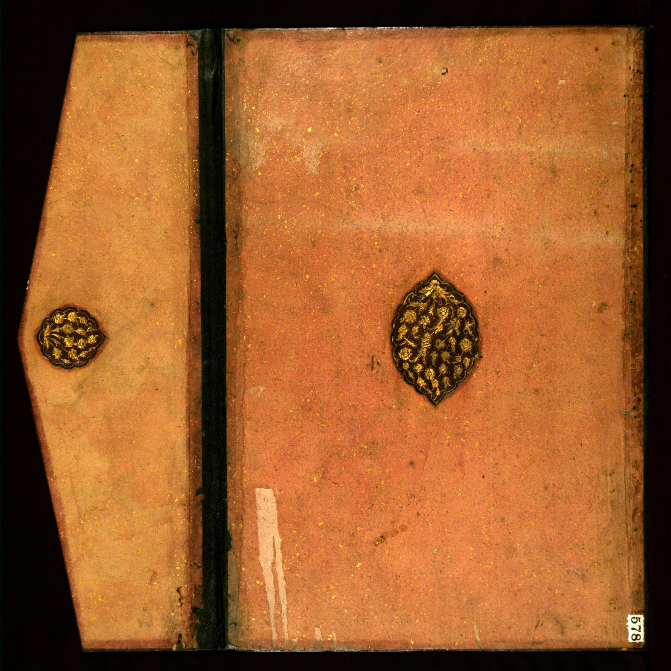 Binding of gold-sprinkled pink paper over pasteboard with central lobed gold-tooled medallion dating to the late 11th century AH/AD 17th or the 12th century AH/AD 18th.